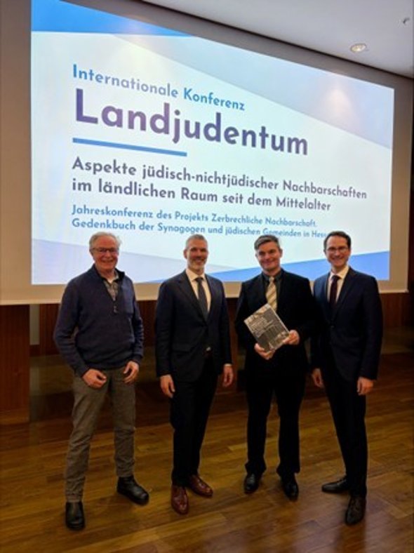 Von links: Dr. Gerhard Brunst (Stadtrat, Stadt Groß-Umstadt), Daniel Neumann (Vorsitzender der Jüdischen Gemeinde Darmstadt und Mitglied im Zentralrat der Juden in Deutschland), Daniel Ristau (Mitautor des Gedenkbuchs und Verfasser des Schaafheim-Kapitels), Bürgermeister Daniel Rauschenberger (Gemeinde Schaafheim). Aufnahme anlässlich der Präsentation des ersten Bandes von „Zerbrechliche Nachbarschaft“ an der Goethe-Universität Frankfurt.